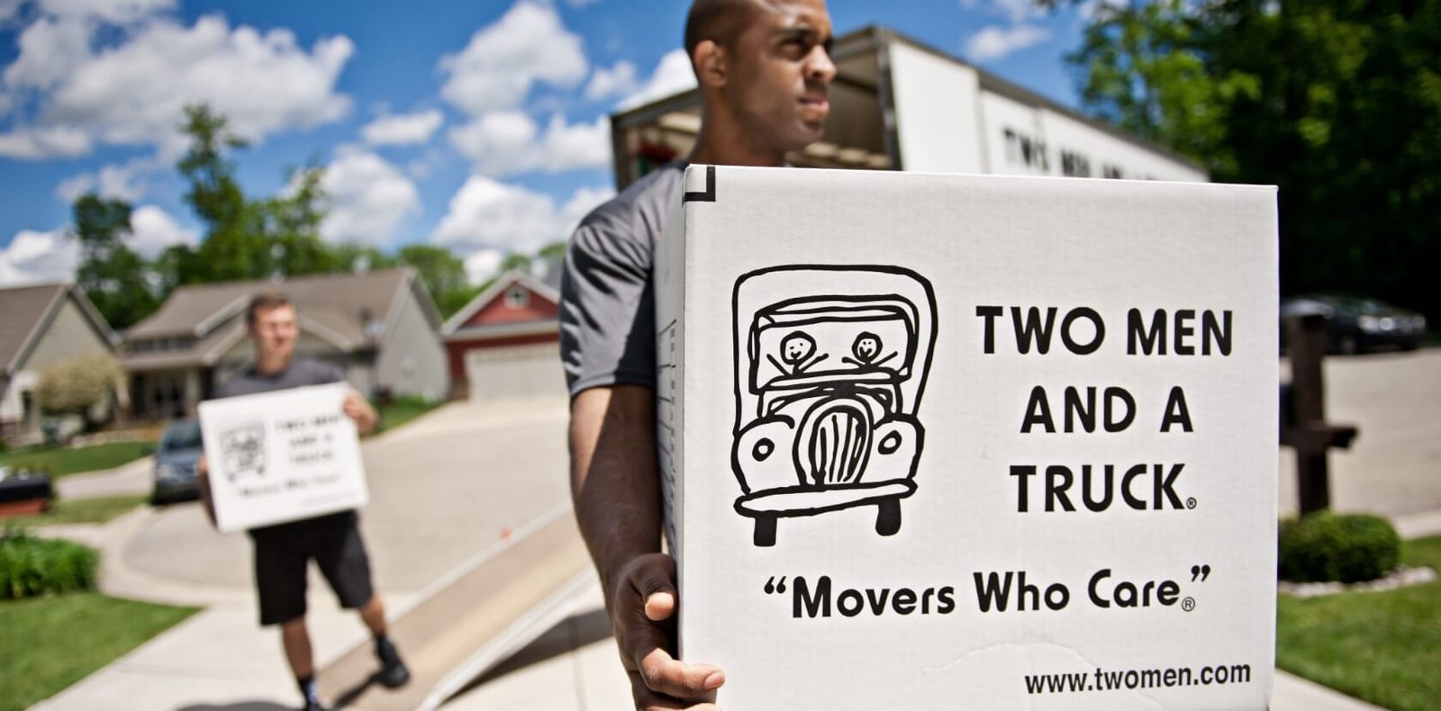 Two Men and a Truck worker carrying box