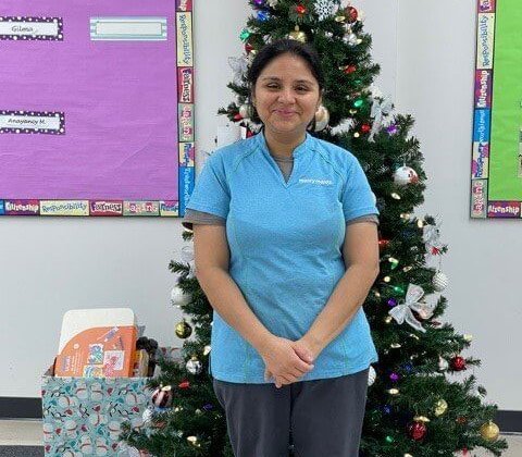 Vilma Castro del Cid standing in front of a Christmas tree